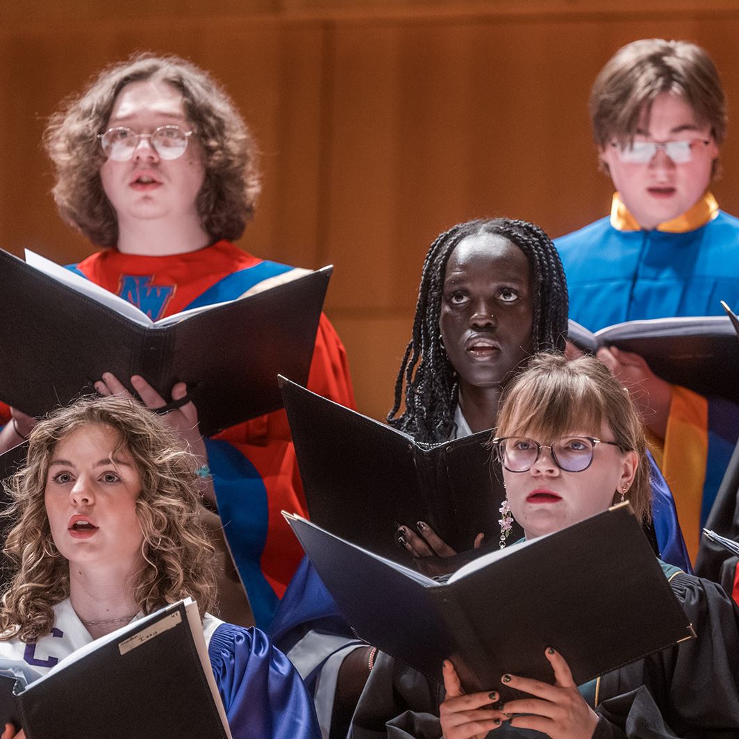  Students sing onstage in choir robes